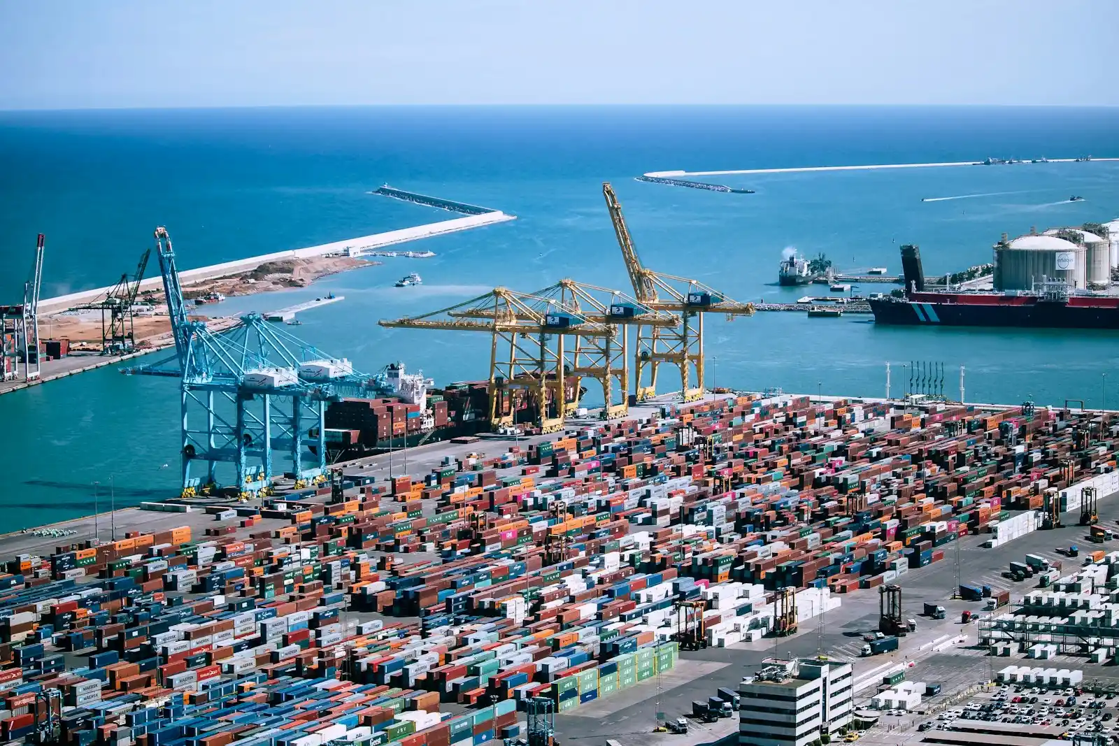 Aerial view of a port packed with thousands of shipping containers beside gantry cranes